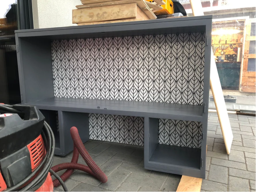 Graues Regal mit Mustertapete