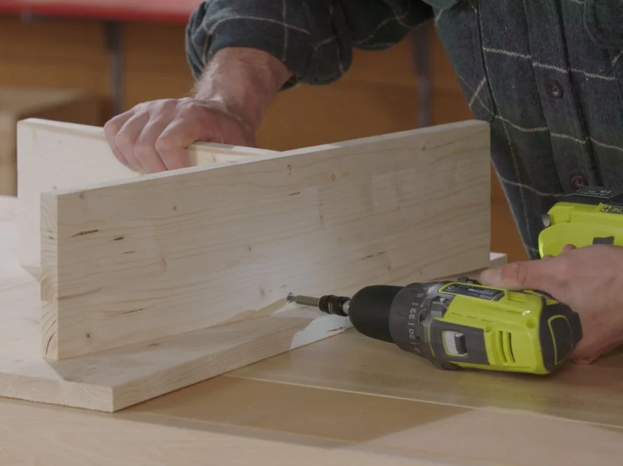 Person verschraubt Holz mit Akkuschrauber