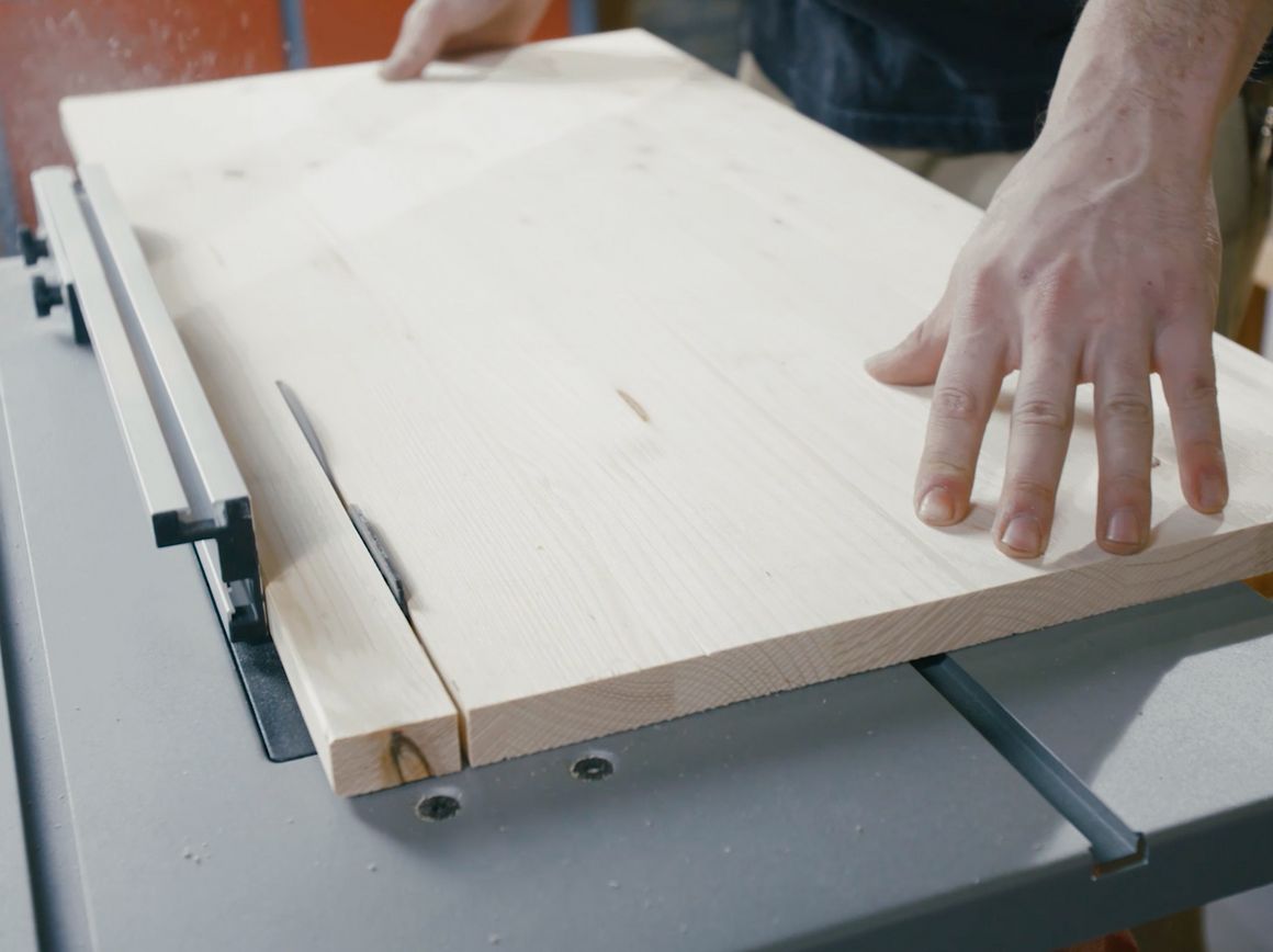 Person sägt Holzbrett mit Tischkreissäge