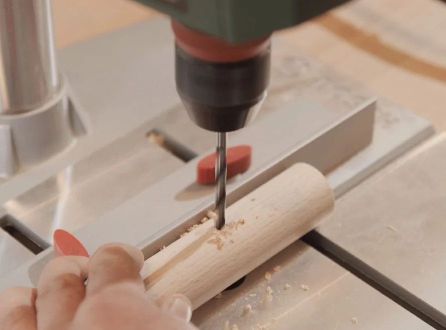 Person bohrt mit Bohrer in Holz