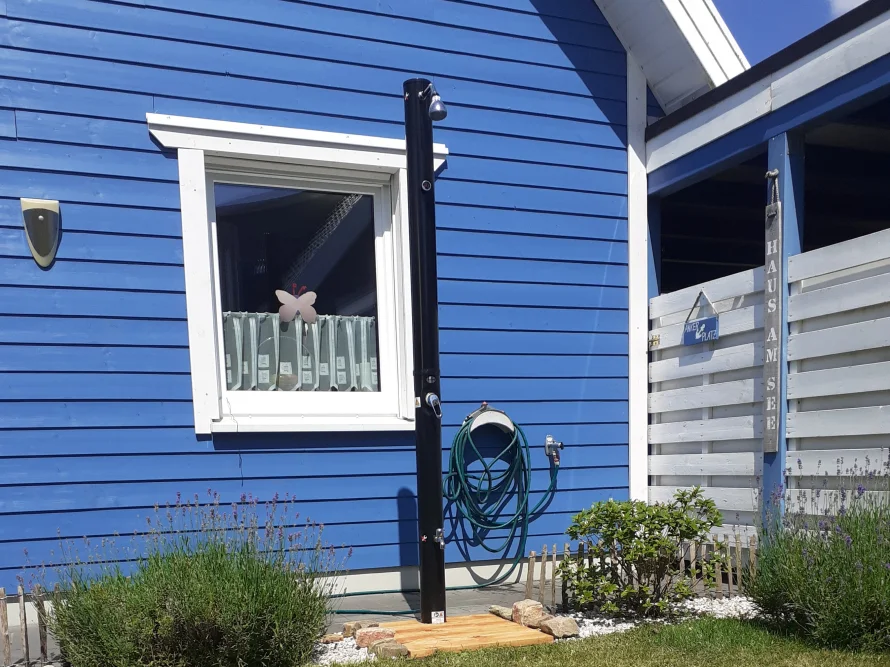 Solardusche an blauer Hauswand