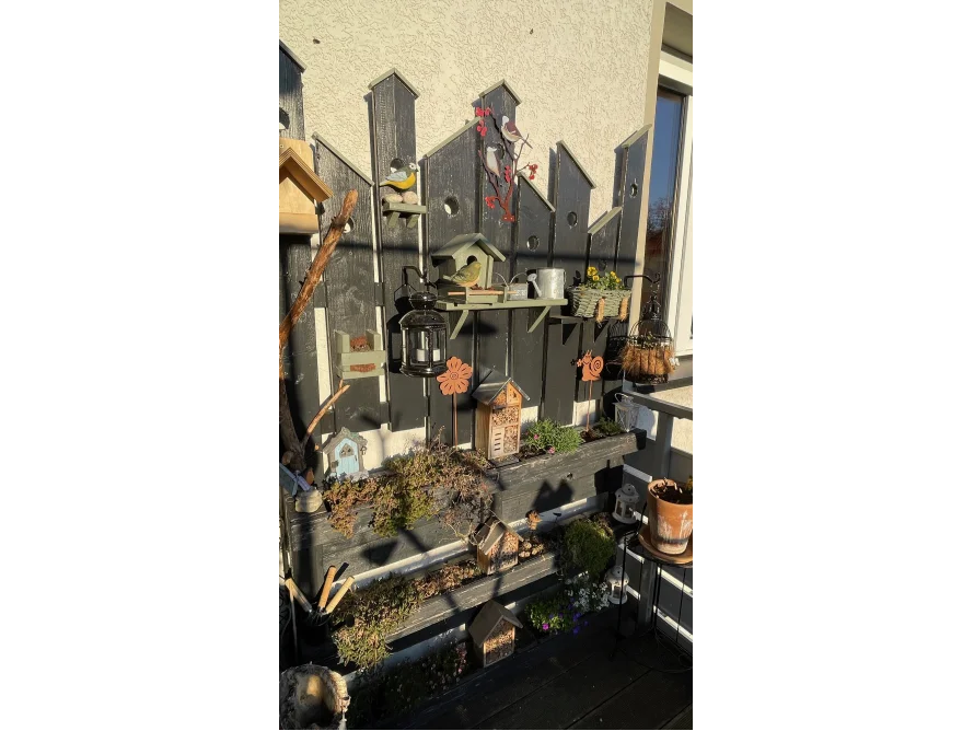 Vogelhäuser an Holzwand auf Balkon