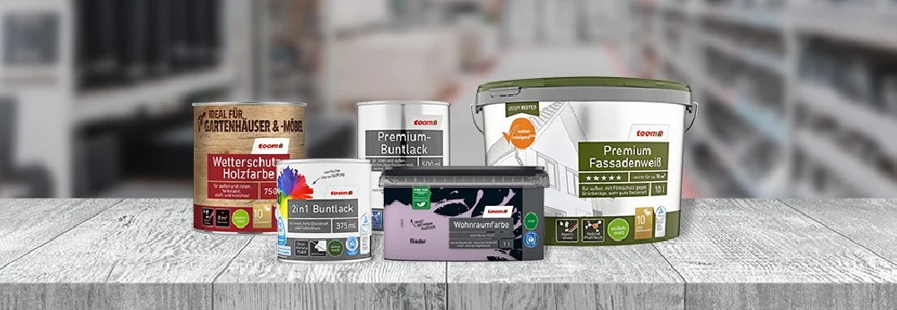 Fünf verschiedene Farbeimer auf einem Tisch