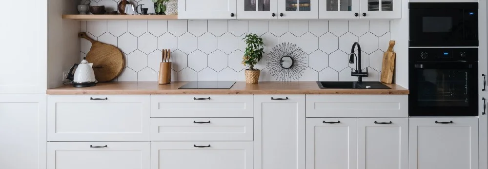 Moderne Küche mit weißen Schränken und Holzarbeitsplatte