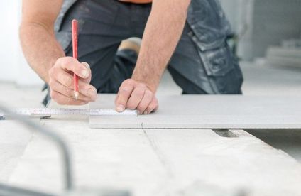 RT Fliesen schneiden Markierung einzeichnen 20 44 717x467 Handwerker markiert Schnittstelle auf Fliese mit Bleistift