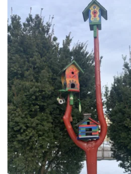 Drei bunte Vogelhäuser auf einem roten Stamm