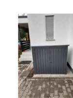 Grauer Geräteschrank an Hauswand