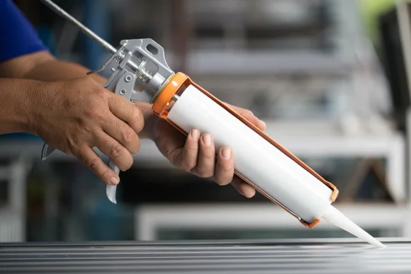 Hände tragen eine Kartuschenpistole