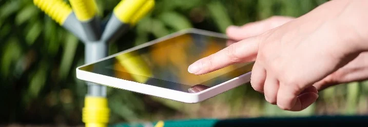 Hand bedient Tablet neben Bewässerungssystem