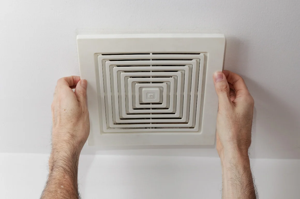 Hände befestigen Abdeckung eines Badlüfters