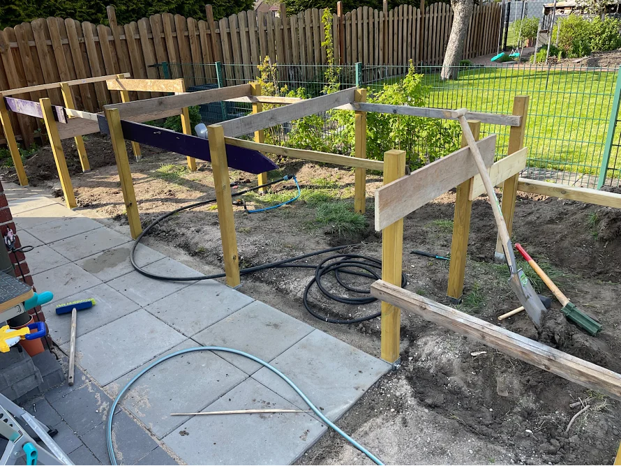 Holzgerüst mit Spaten im Garten