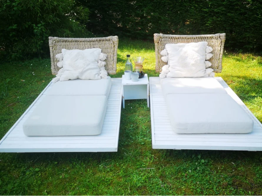 Zwei weiße Gartenliegen auf dem Rasen