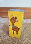 Zwei aufeinandergestapelte, bemalte Holzklötze mit einer Giraffe.
