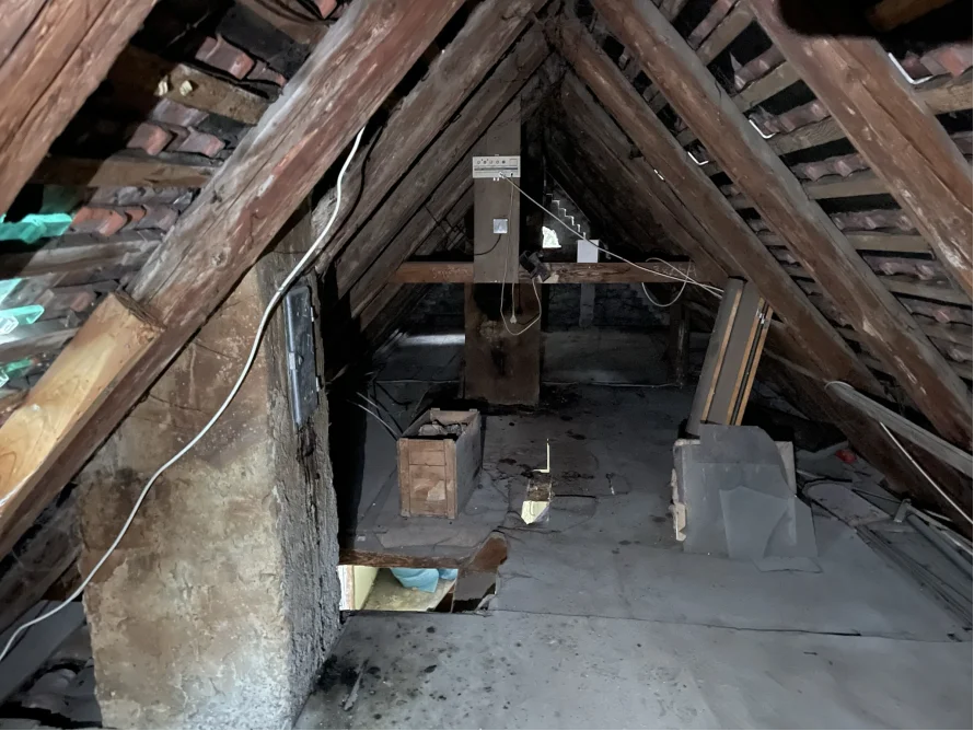Dachboden mit Holzbalken und Ziegelsteinen