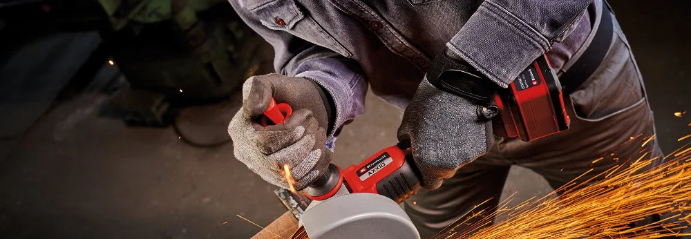Person bearbeitet Metall mit Winkelschleifer