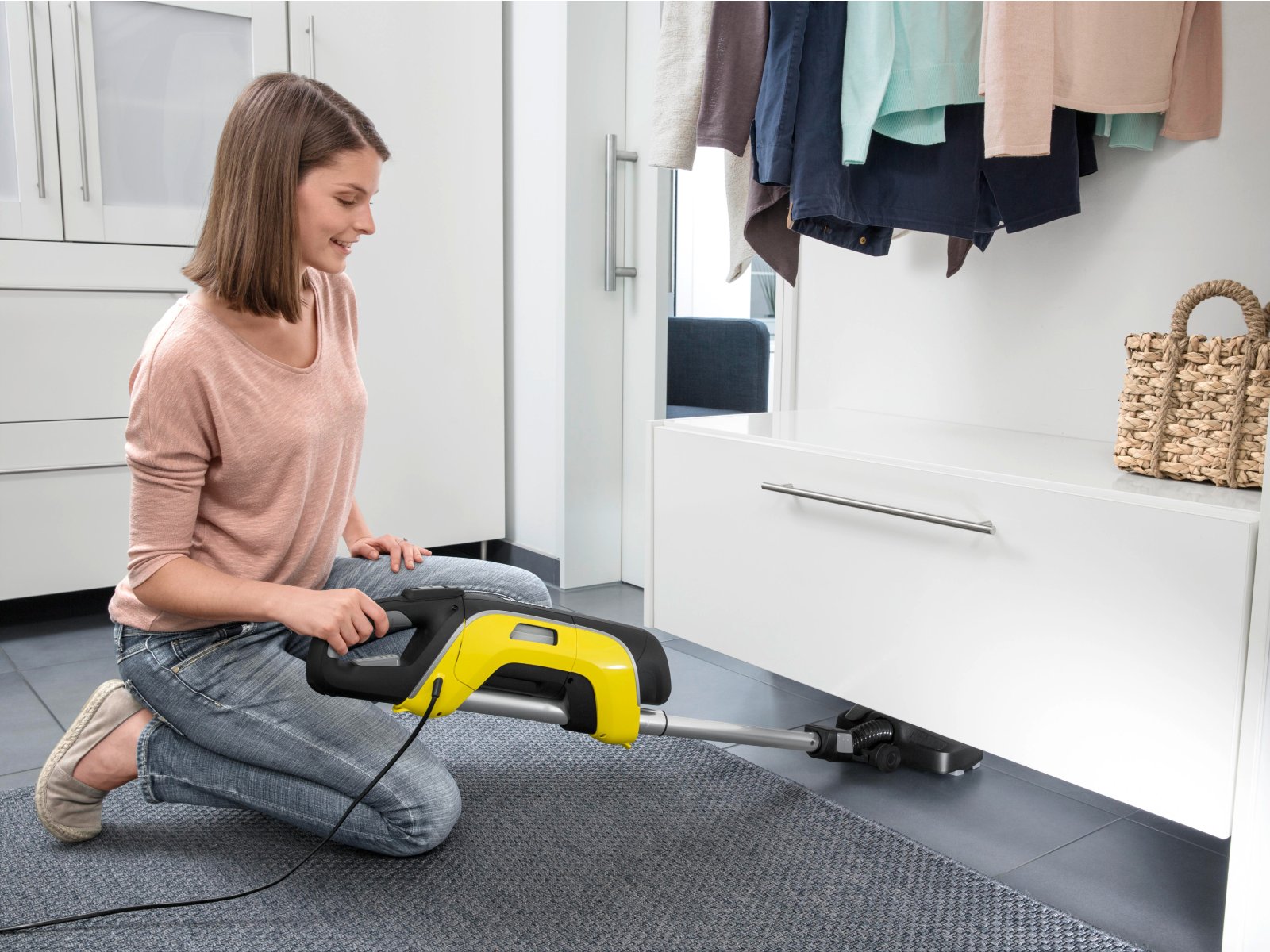 Person saugt mit einem Stielstaubsauger