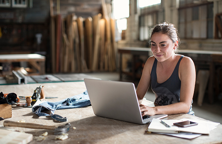 Toom-Gutschein-Tag - NUR HEUTE - Je 100€ Einkauf 20€ Gutscheinkarte GRATIS erhalten (online und im Markt) 2 Frau sitzt am Laptop in Werkstatt