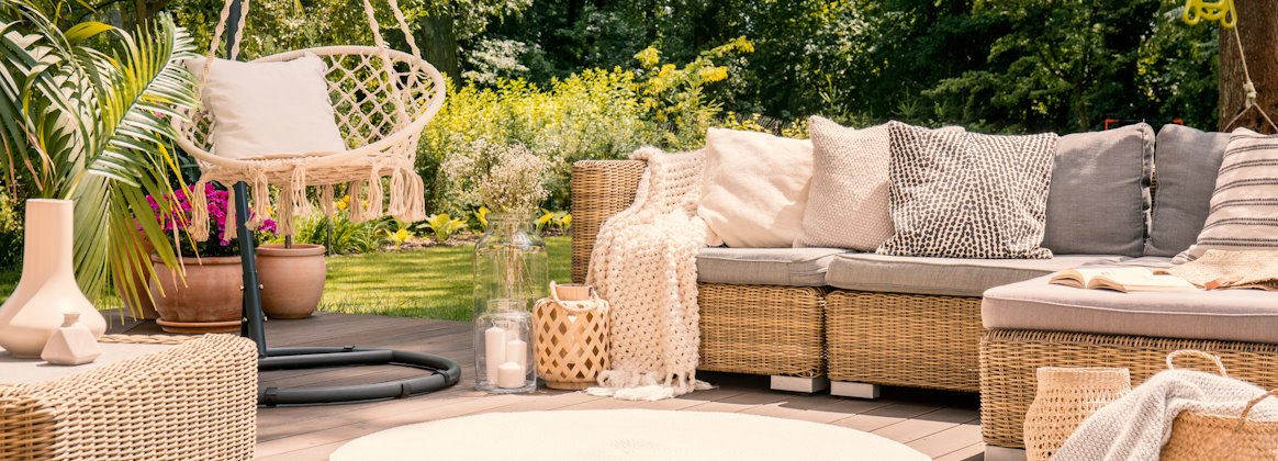 Rattan-Gartenmöbel auf einer hellen Terrasse