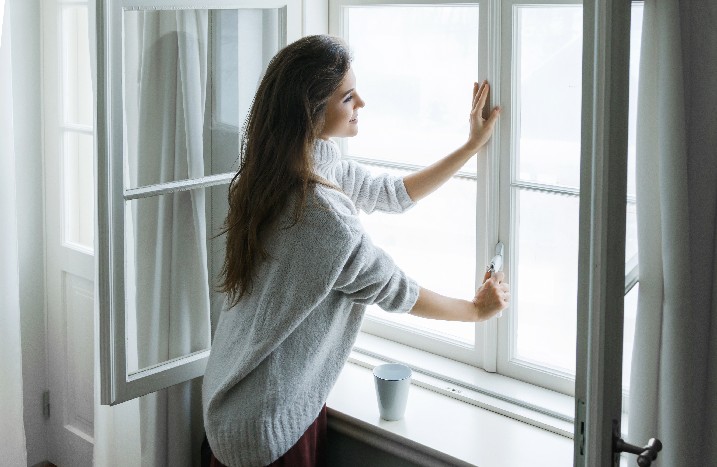 Frau schließt Fenster
