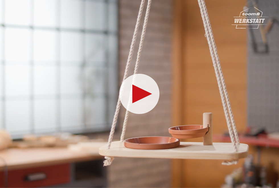 Vogeltränke aus Ton auf Holzbrett