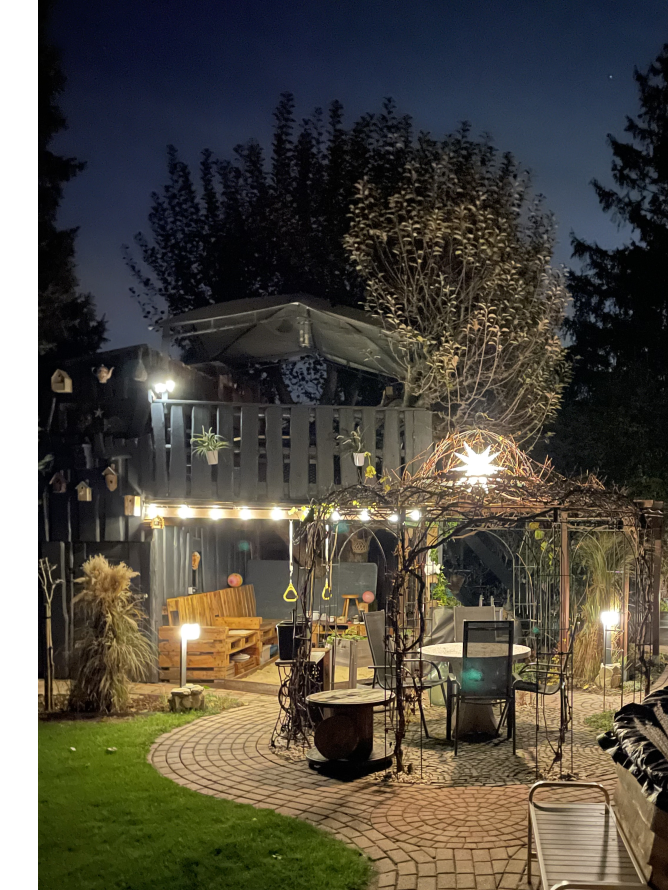 Gemütlicher Garten mit beleuchtetem Baumhaus und Sitzecke