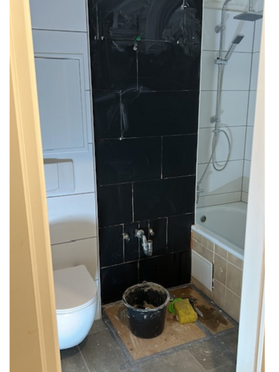 Badezimmer während der Renovierung mit schwarzen Fliesen