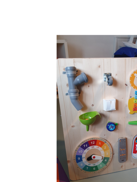 Ein Holzbrett mit verschiedenen bunten sensorischen Spielzeugen.