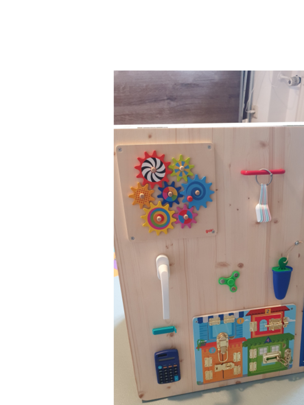 Ein Holzbrett mit verschiedenen bunten sensorischen Spielzeugen.