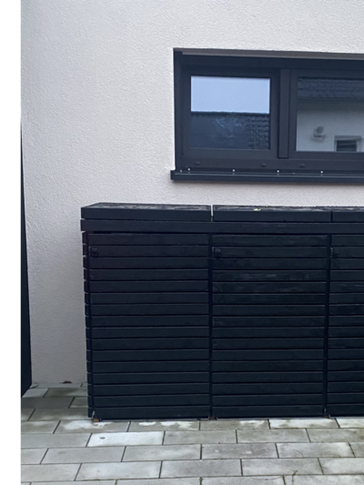 Schwarze Mülltonnenbox aus Holz