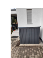 Grauer Geräteschrank an Hauswand