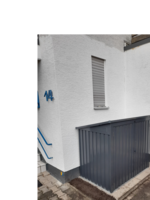 Graues Gartenhaus an Hauswand