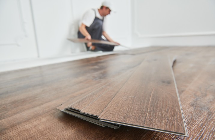 Mann verlegt im Hintergrund Klick-Vinyl-Platten