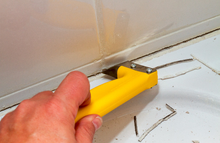Altes Silikon wird mit Cuttermesser entfernt.