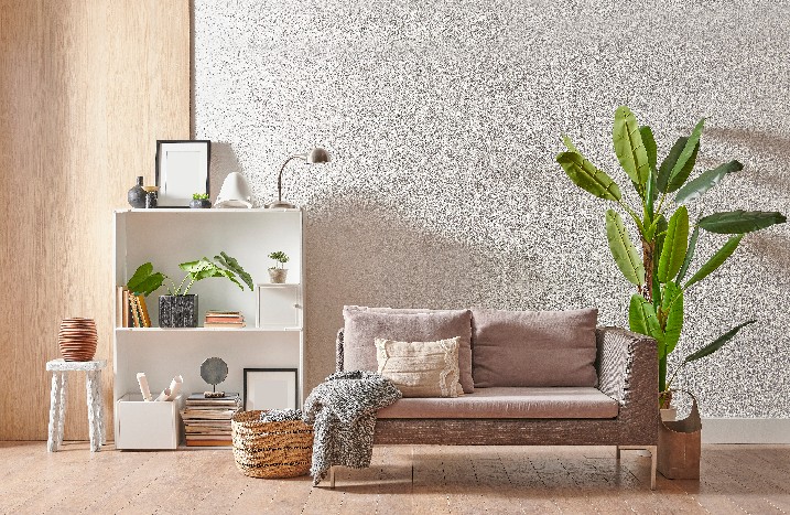 Zeitlos eingerichtetes Wohnzimmer vor Wand in Betonoptik.