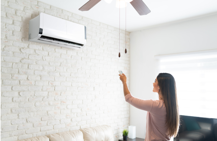 Frau schaltet Klimaanlage an