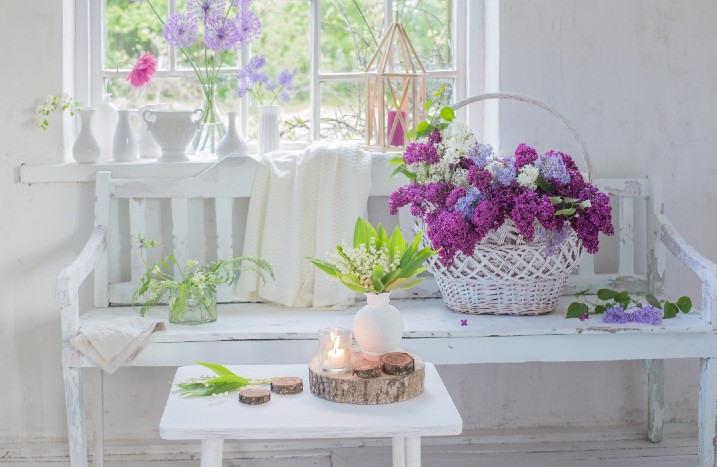 Dekorative Blumen auf Bank im Shabby-Chic-Style