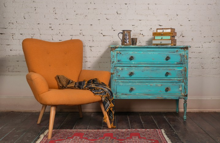 Sessel und bläuliche Kommode im Shabby-Chic-Style