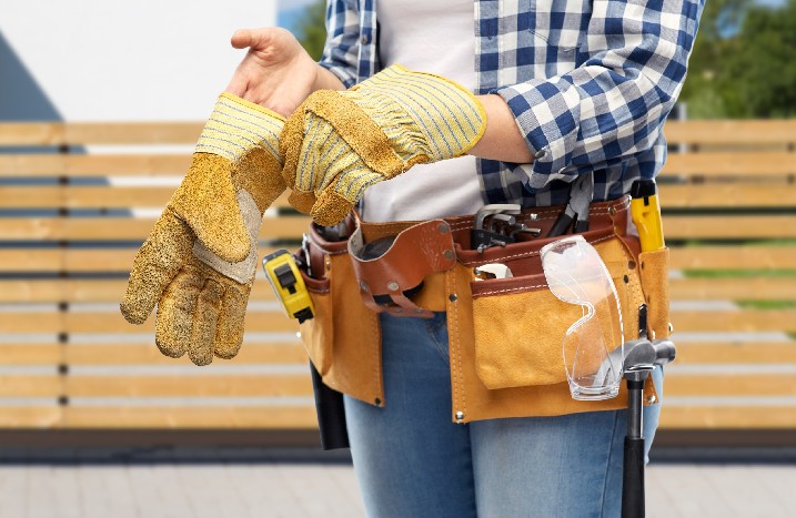 Arbeiterin zieht Schutzhandschuhe an