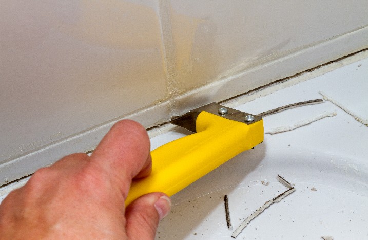 Silikon wird mit Cutter-Messer entfernt
