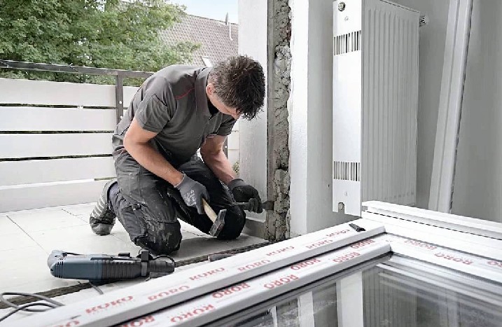 Ein Mann bearbeitet das Mauerwerk für die neue Terrassentür.