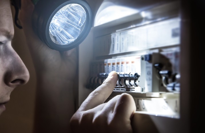 Mann schaltet Sicherung aus