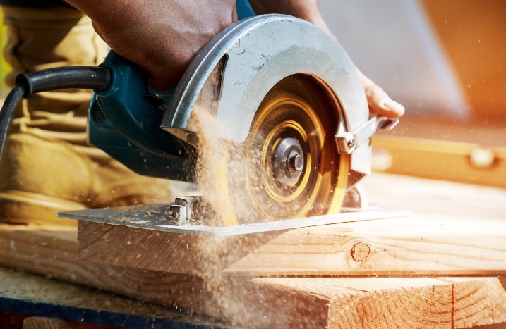 Holz wird mit Säge zugeschnitten