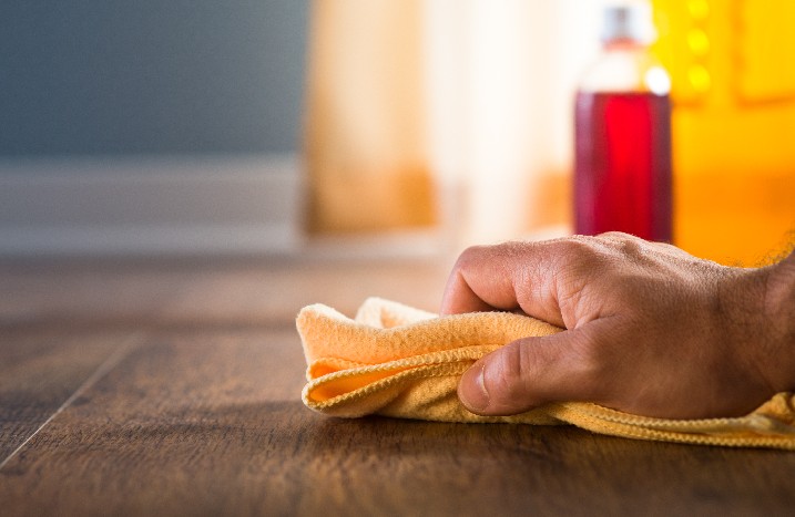 Hand wischt mit Tuch über Boden