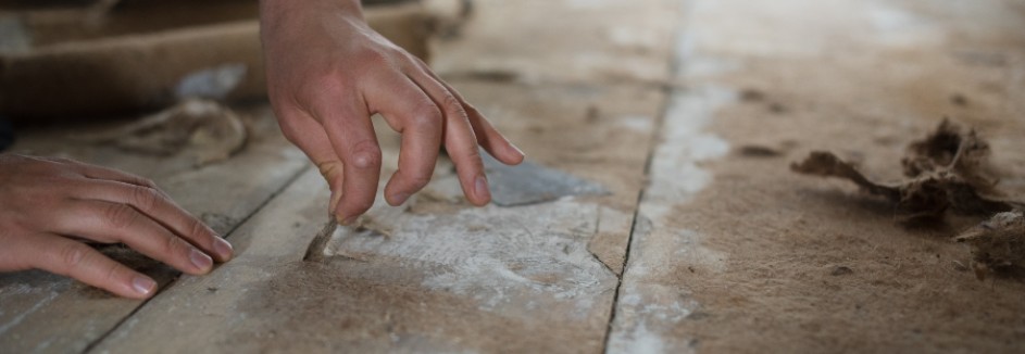 Hand entfernt per Hand Klebreste auf dem Fußboden