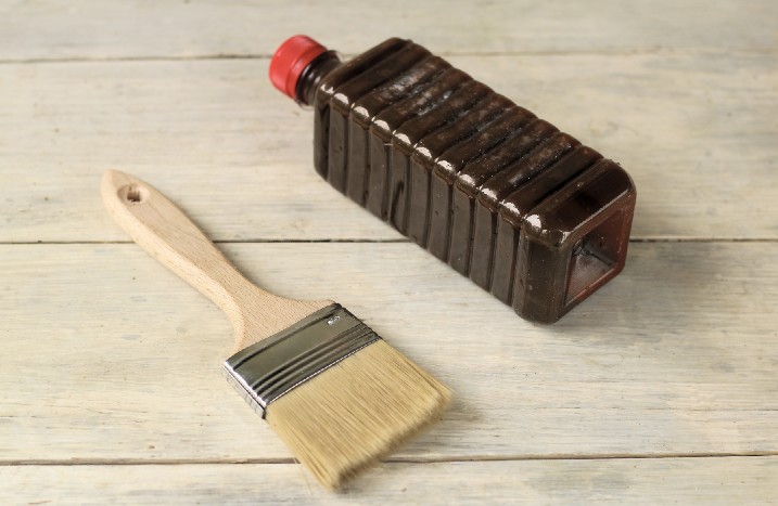 Pinsel und Flasche auf Holzbrettern