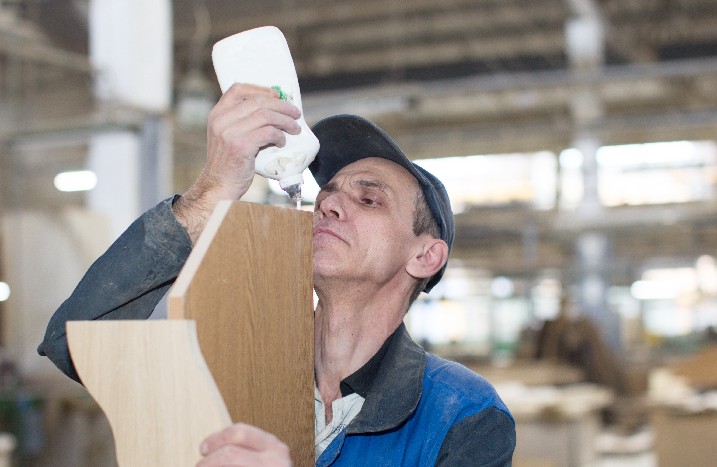 Mann klebt Holzfurnier