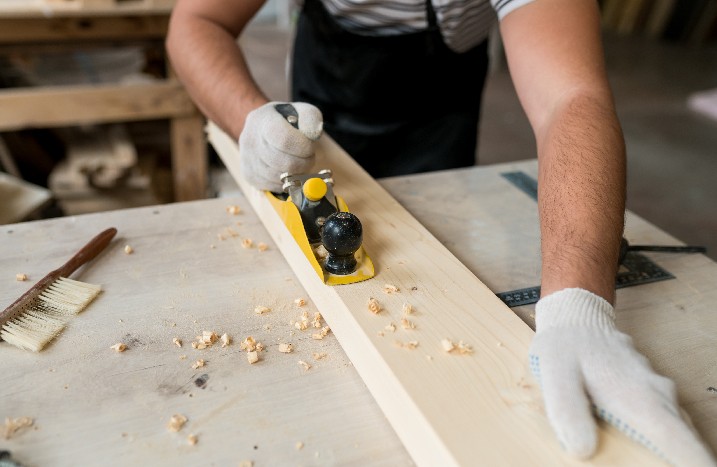 Nahaufnahme von einem Mann, der Holz hobelt