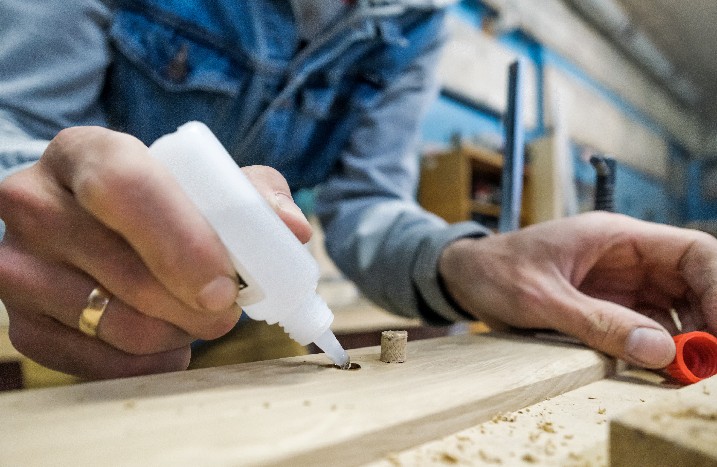 Klebstoff wird auf Holzfläche aufgetragen