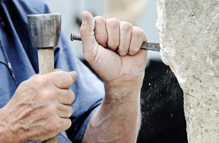 Stein wird mit Hammer und Meißel bearbeitet