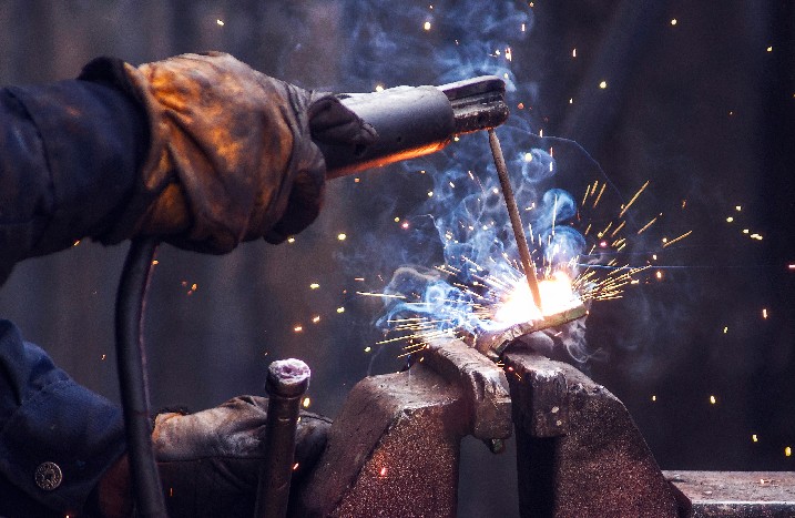 Industriearbeiter schweißt Eisenstücke bei der Arbeit
